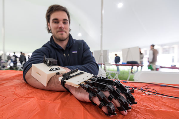 A student wearing a robotic arm.