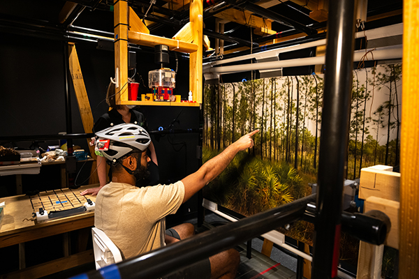 A test subject performs experiments while wearing a specialized helmet and scleral coil used in eye tracking measurements. 