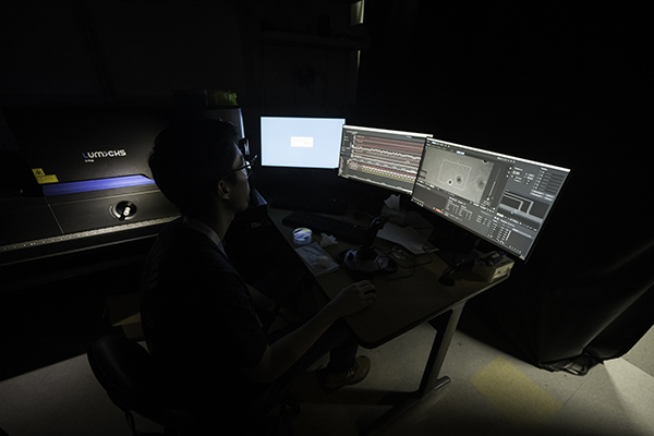 A researcher operating a device in a lab.