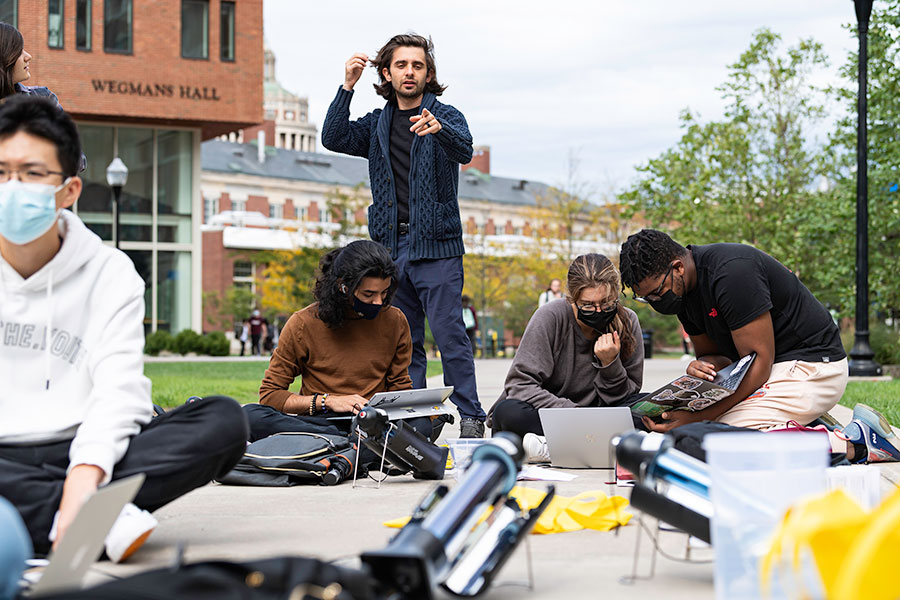 Marc Porosoff (standing) works with first-year students in his CHE 150: Introduction to Sustainable Energy class who are testing their solar hot water heaters on the Hajim Quad. (Photo by J. Adam Fenster/University of Rochester)