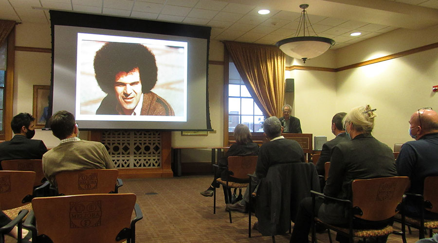 A group of people gathered in the library to watch a slideshow.