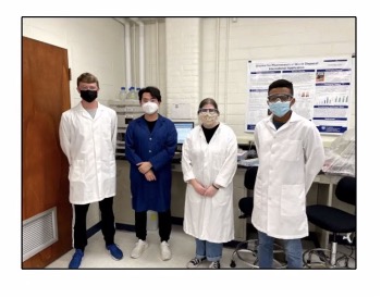 A group photo of the students working on the project wearing lab coats.