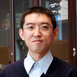 Man smiling at camera wearing glasses.