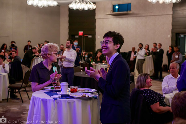 A student standing with an industry partner during the spring 2022 symposium.