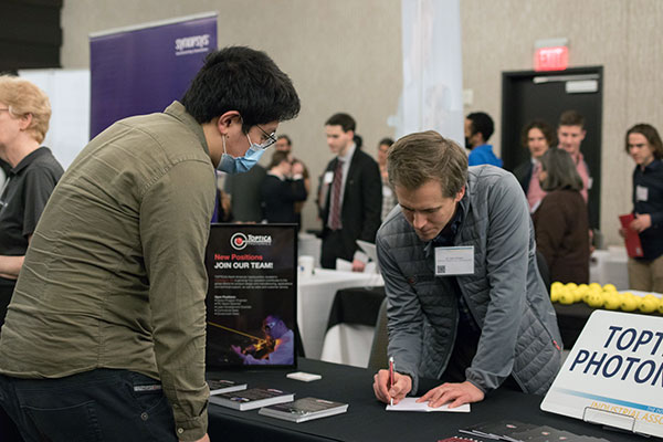 A student speaking with an industry partner during the spring 2022 symposium.