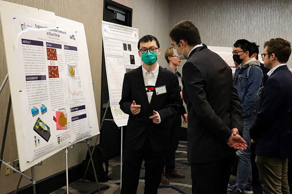 A student speaking to an industry associate at the spring 2022 symposium.
