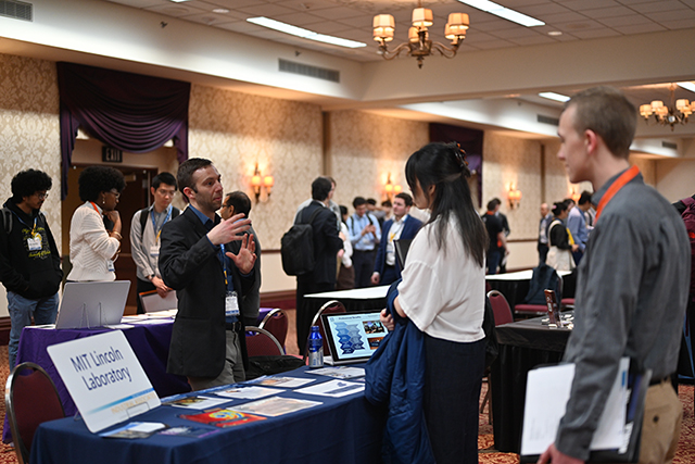 People speaking to a representative of an organization during an event.