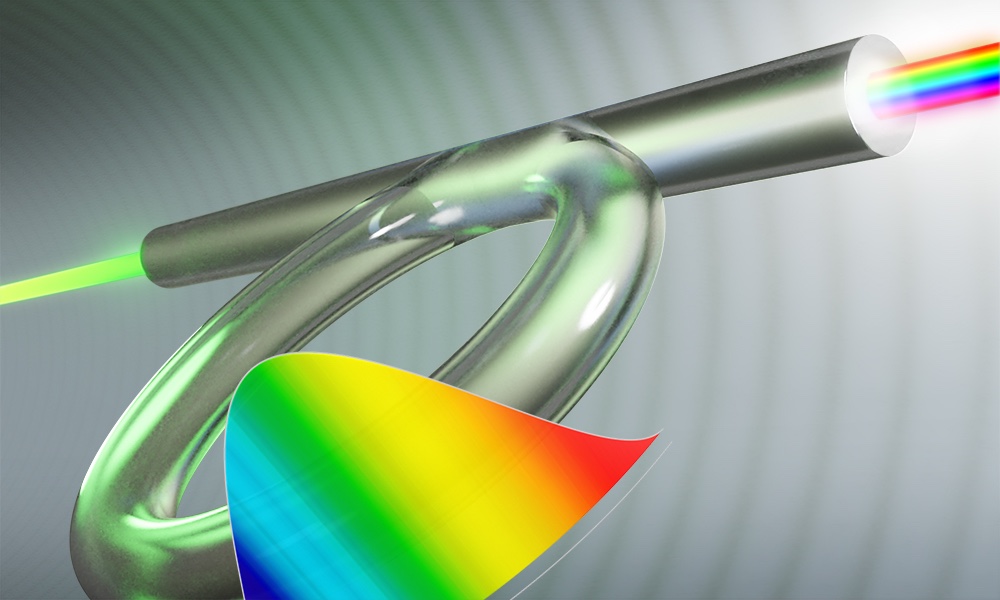 An illustration of the optical fiber Kerr resonator, which Rochester researchers used with a spectral filter to create highly chirped laser pulses. The rainbow pattern in the foreground shows how the colors of a chirped laser pulse are separated in time. (University of Rochester illustration / Michael Osadciw)