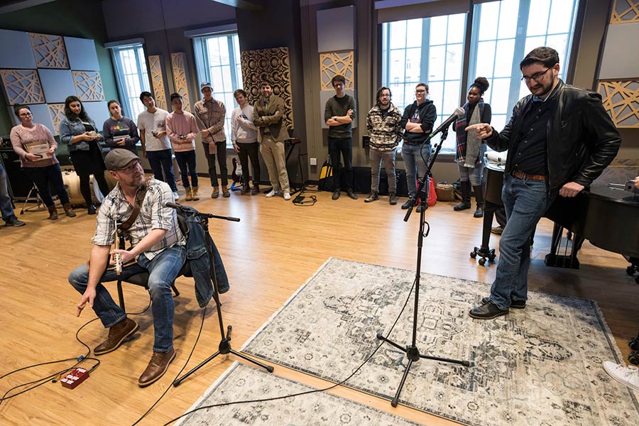 The artist tests the pedal in front of the class.