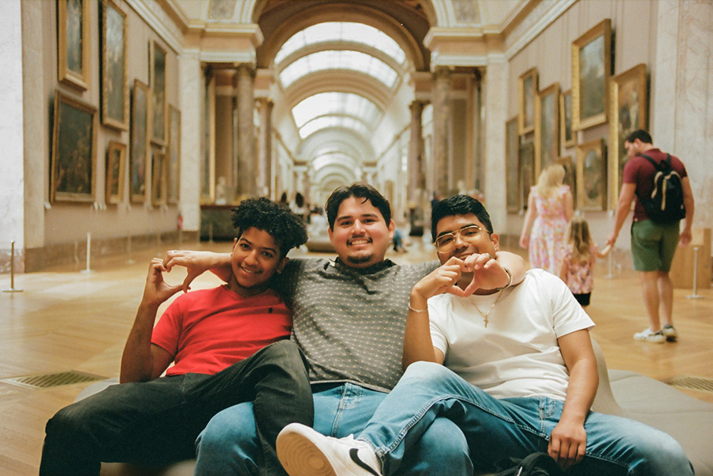 Three people smiling at the camera inside a beautiful building.