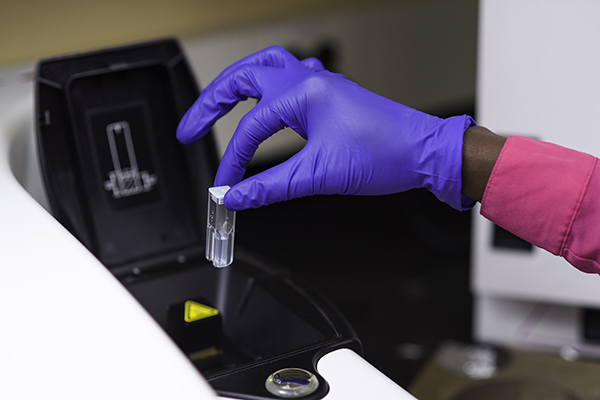 A sample in a cuvette being placed in a zetasizer.