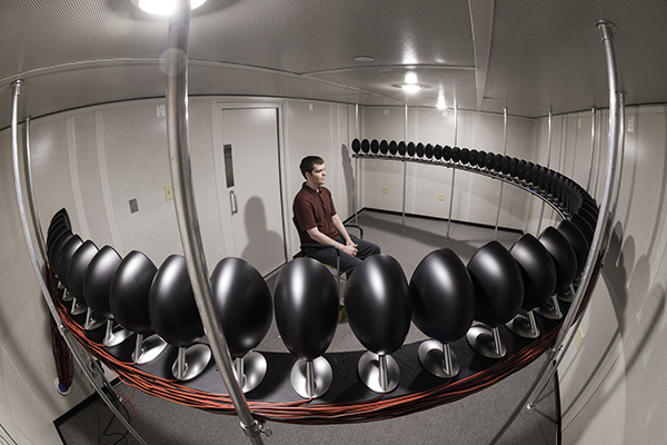 A student testing LEDs lining a loudspeaker array.