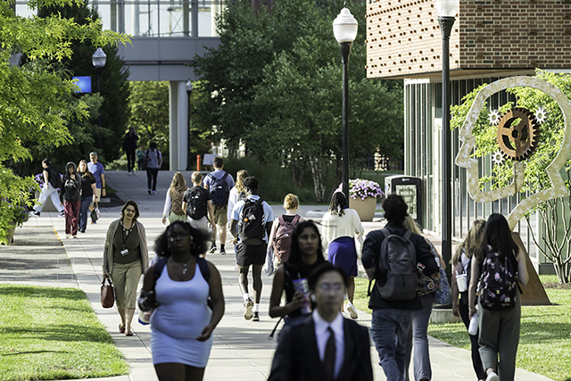 A view of the Hajim quad with a diverse group of people walking towards their various destinations.