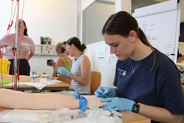 A student volunteer giving an injection.