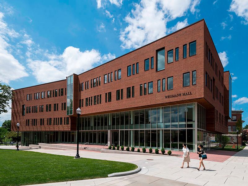 Two students walking on the quad in from of Wegmans Hall.