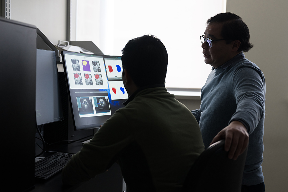 Professor Benjamin Castañeda (R) and a biomedical engineering PhD student use artificial intelligence to process data collected through ultrasound scans to identify lesions.