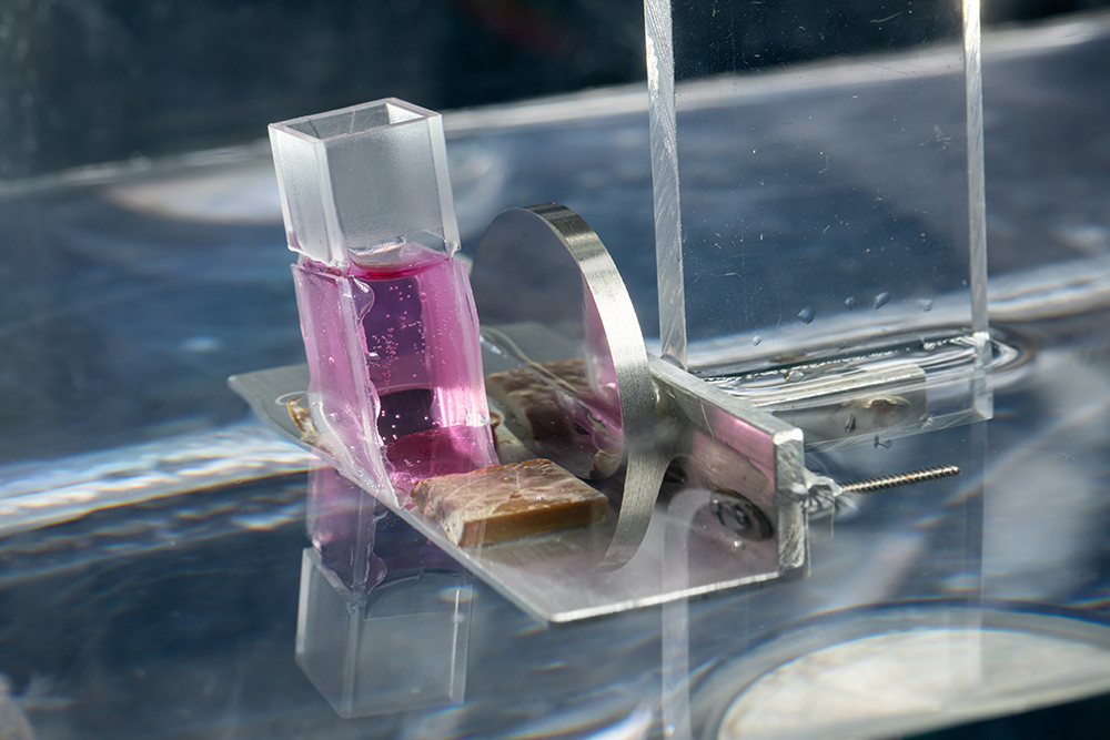 A closeup of a modified cubette with acoustically transparent windows on two opposing sides designed to be used for acoustically patterning cells and collagen.