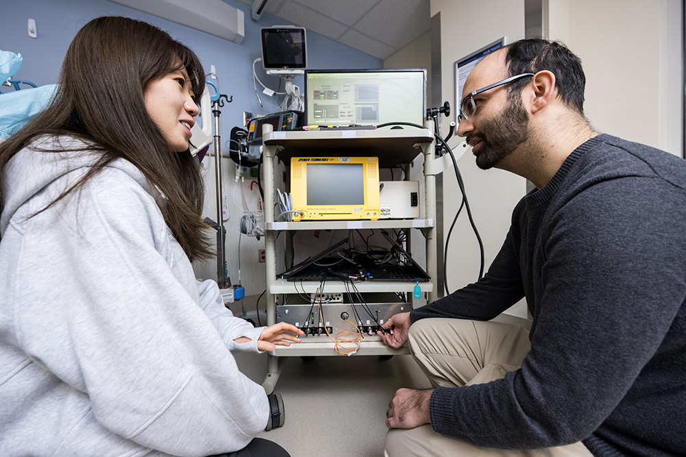 Two students pictured with a device prototype in the cardiac ICU at the University of Rochester Medical Center.