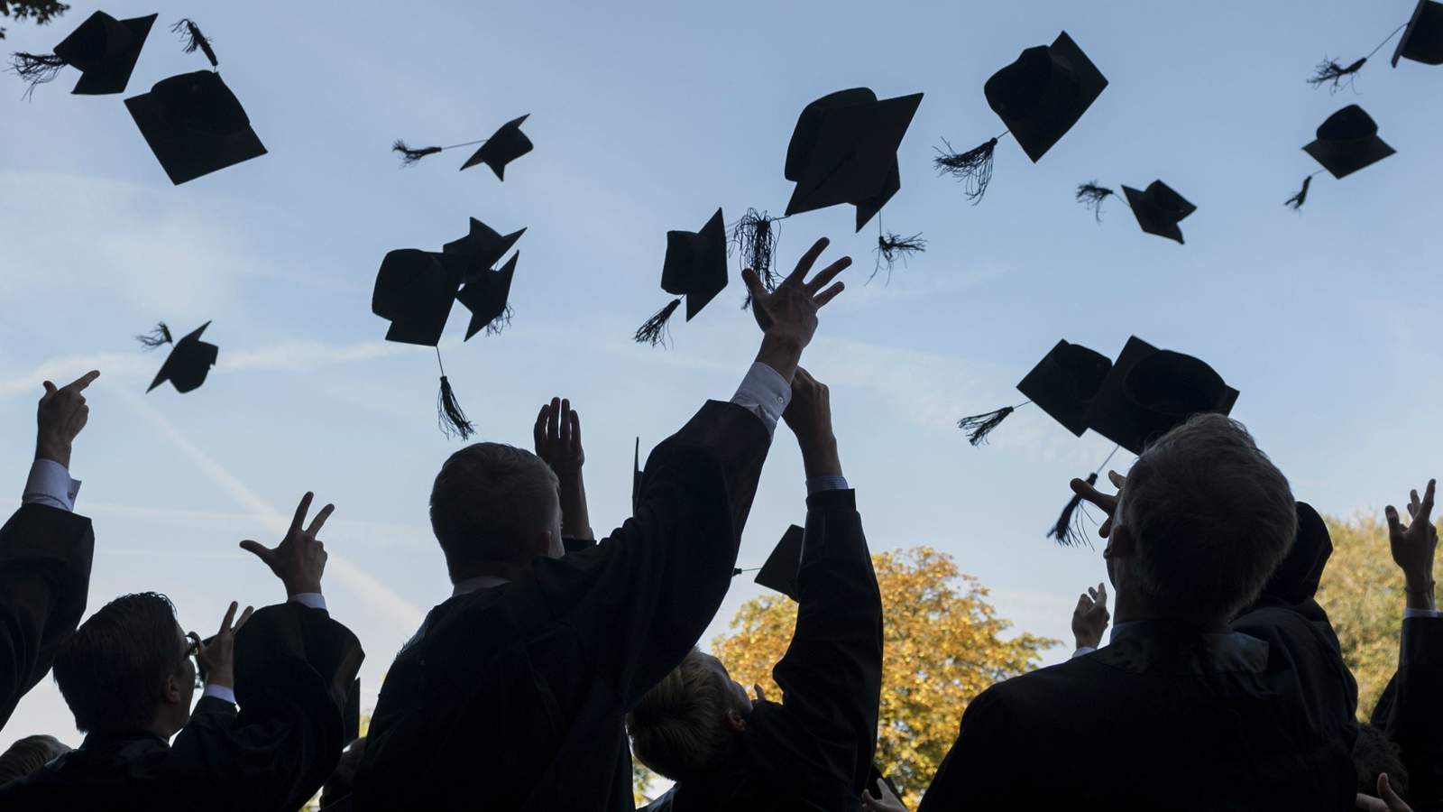 Graduates throwing their caps in the air.