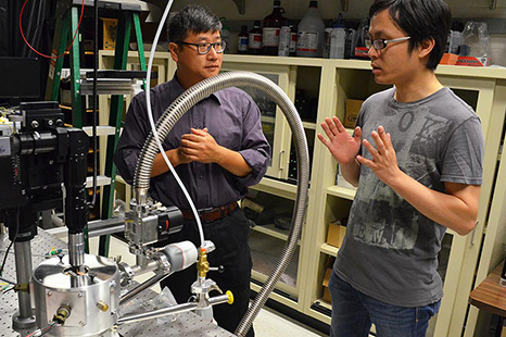 A student and a professor conversing in a lab.