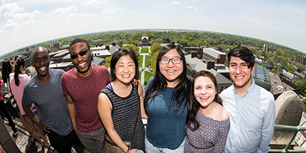 A group of friends standing together at the top of the Rush Rhees Library tower.