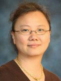 woman smiling at camera wearing red shirt and glasses