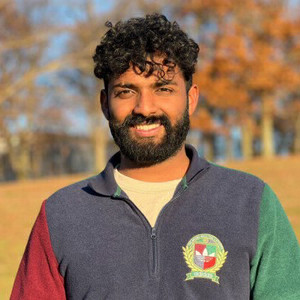 Man with beard smiling at camera wearing colorful sweater