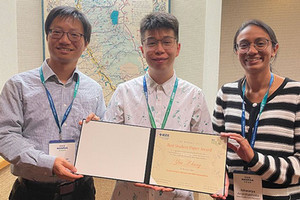 Neil Zhang in center of photo holding up award certificate