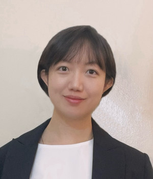 Woman smiling at camera wearing white shirt with black jacket