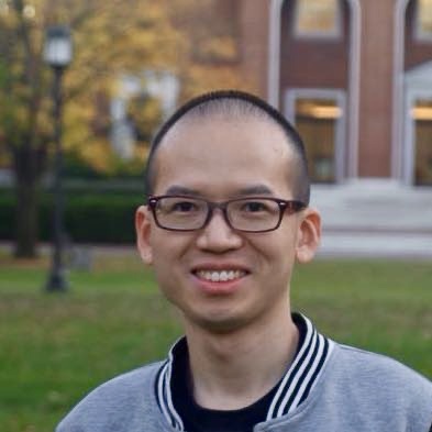 Man smiling at camera wearing white shirt with black jacket