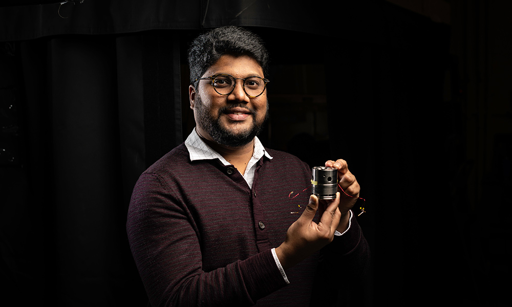 University of Rochester assistant professor of mechanical engineering and physics and astronomy Ranga Dias holds an array containing diamond anvil cells used to compress and alter the properties of hydrogen rich materials.