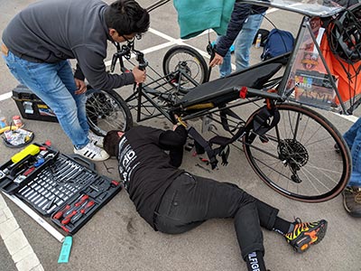 Team members make repairs and adjustments between races.