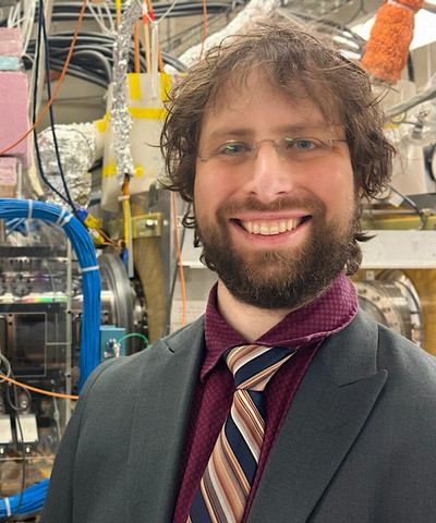 Eugene Evans smiling in front of mechanical equipment. 