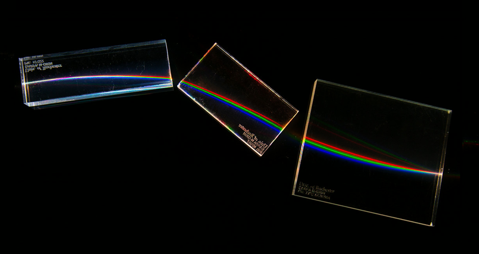 A graphic of light shining through multiple prisms on a black background.