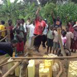 A photo of a Ugandan community using the India Mark II hand pump